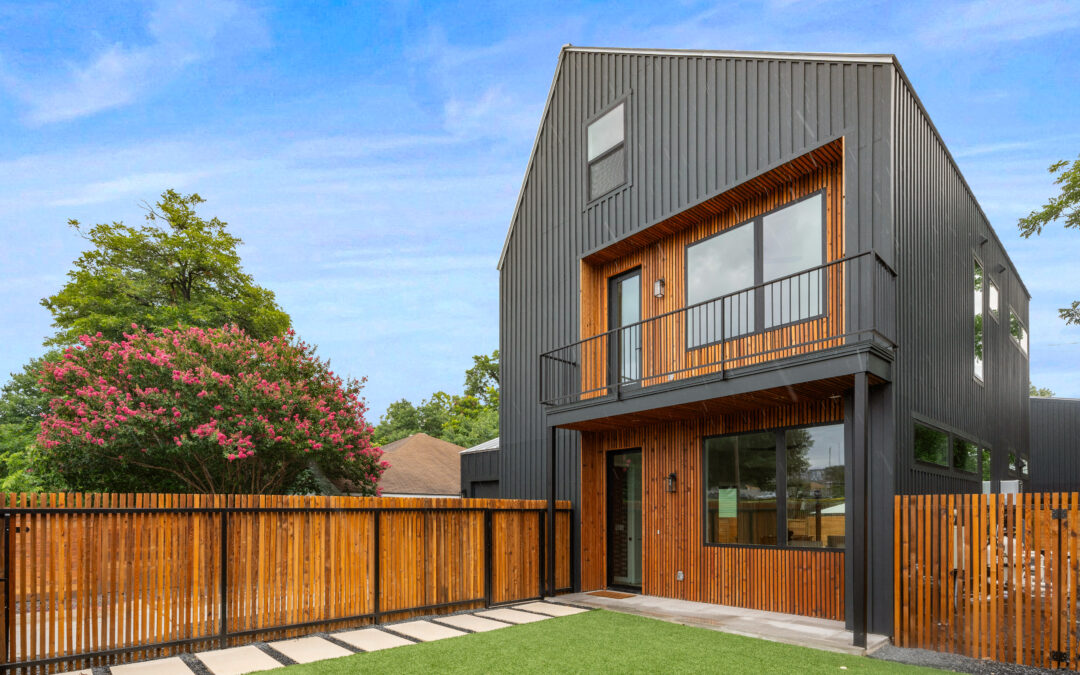 Modern house with wooden fence and lawn.